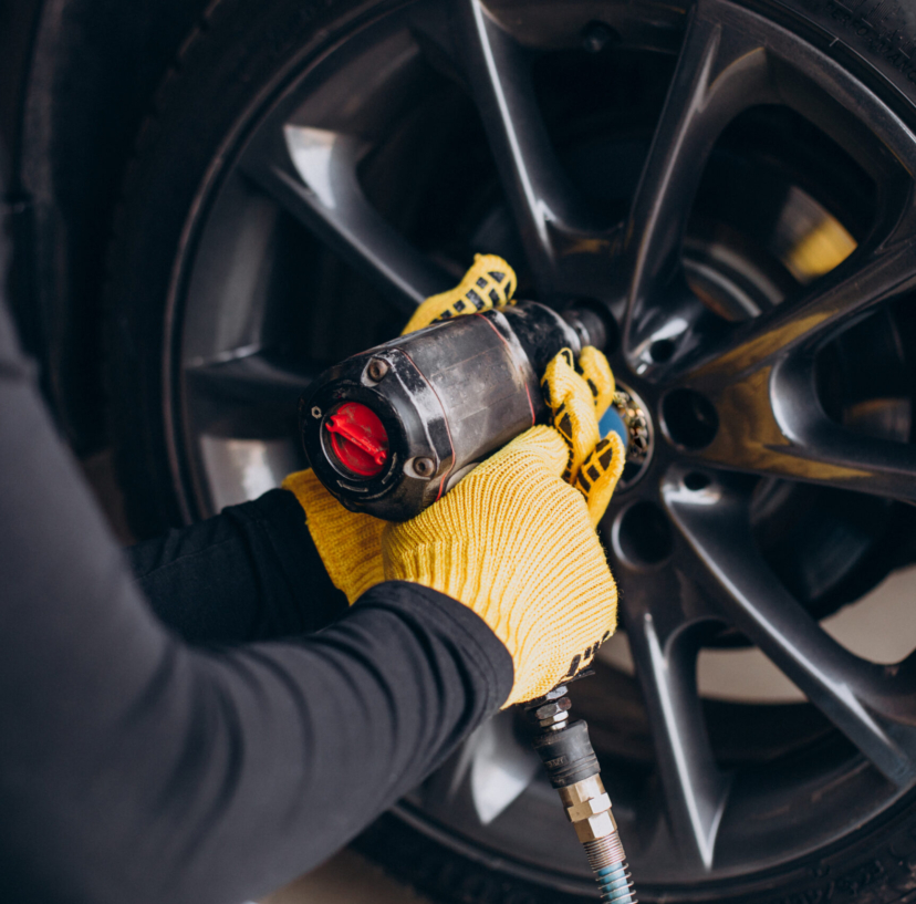 Car mechanic changing wheels in car